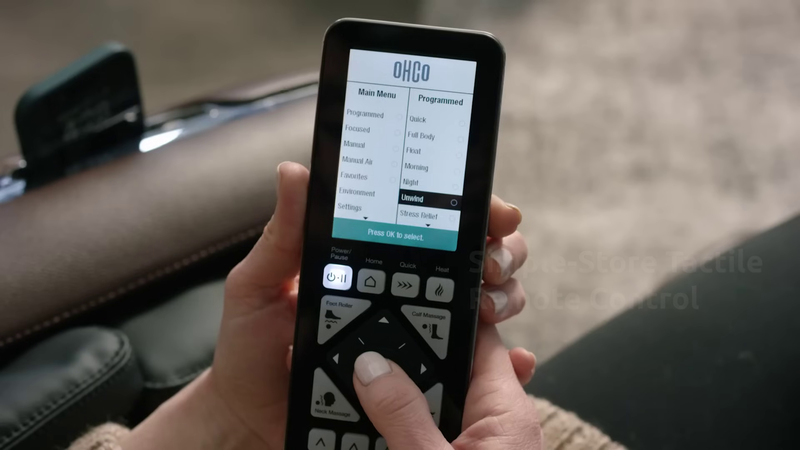 Woman using M8 Neo remote control to select massage program.